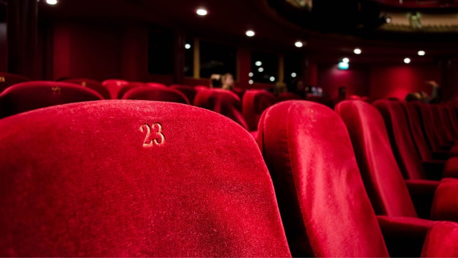 Rows of red seats in a theatre.