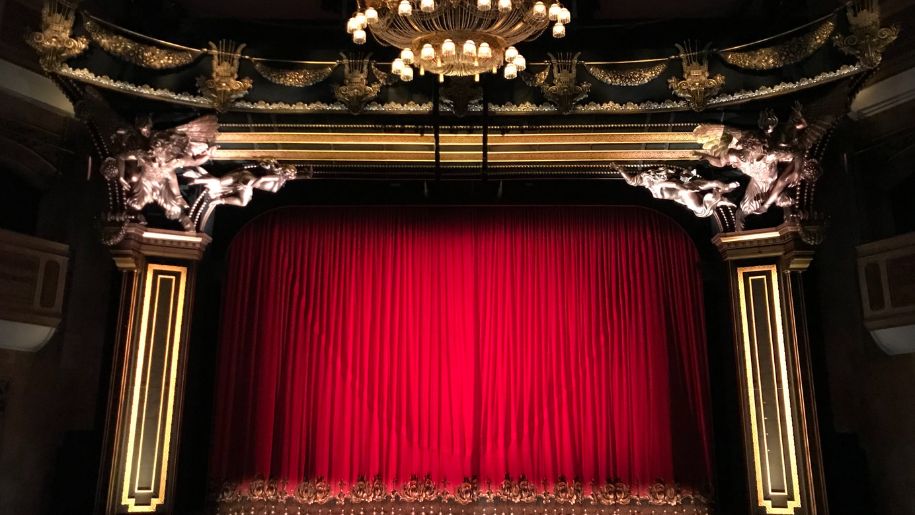 Theatre stage with red front curtain.