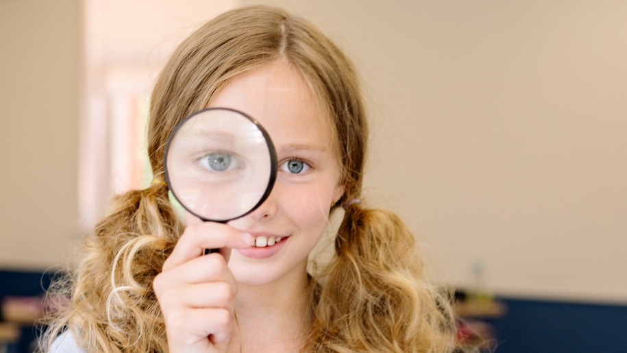 A child with a magnifying glass.