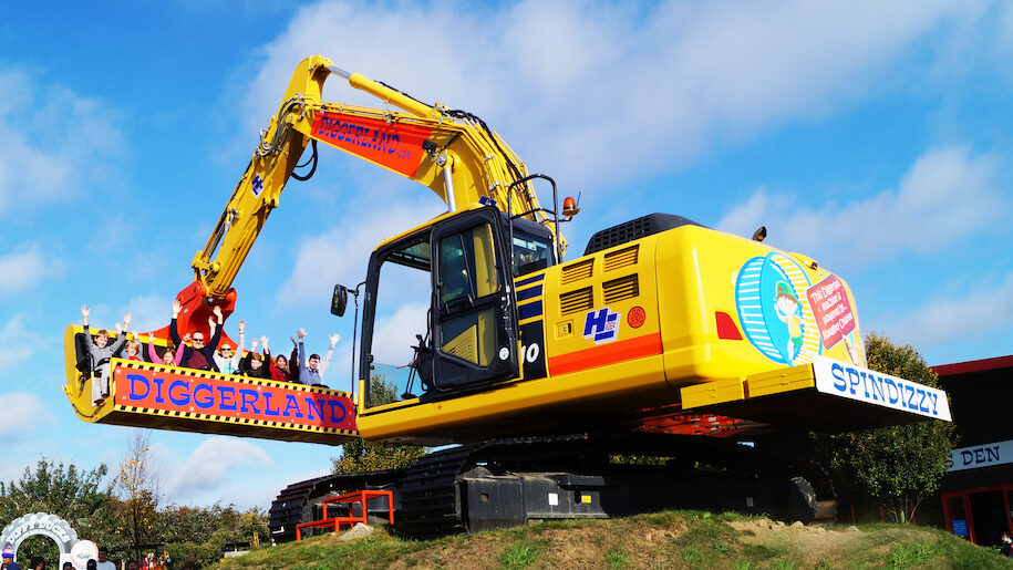 Diggerland large yellow digger with people with hands in air