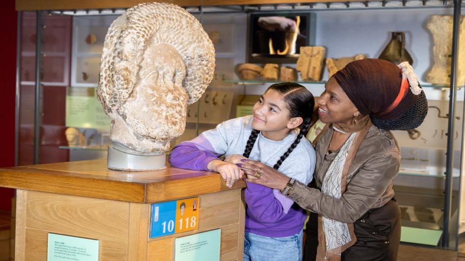 A family enjoying a day out at the Roman Baths in Somerset.