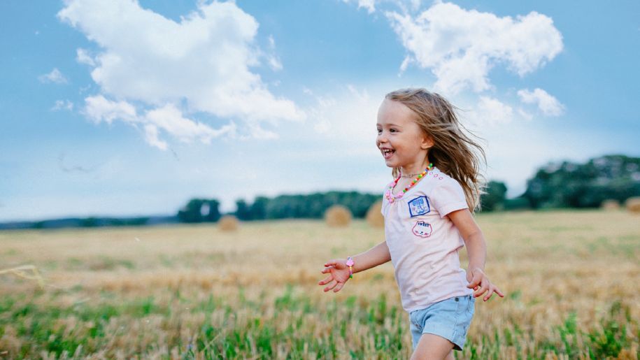 Young girl running through field