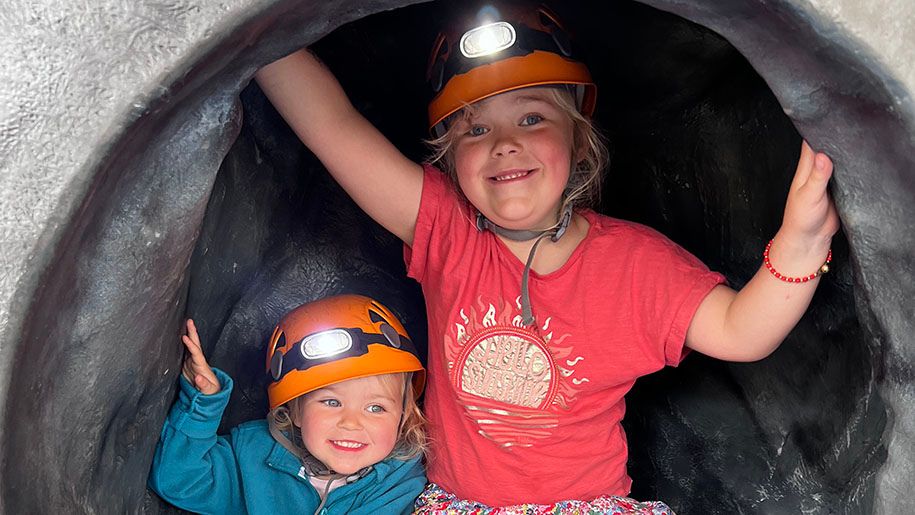 Two young girls playing in a tunnel at Holkham