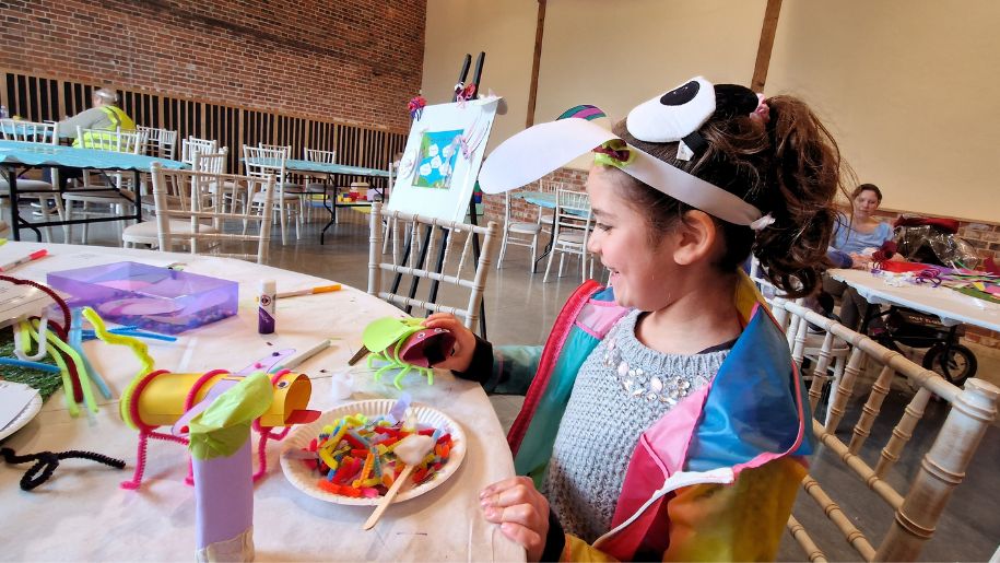 Girl sat at crafts table at West Horsley Place