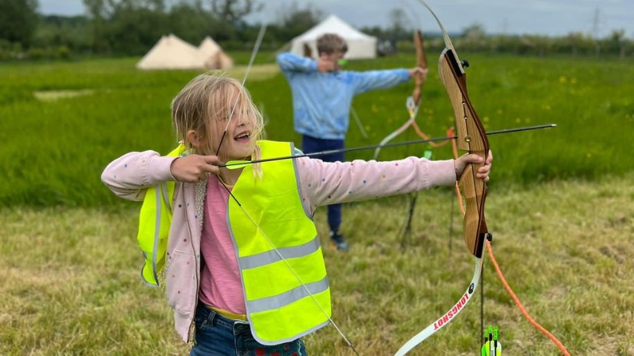 Child enjoying archery at a holiday camp at Hogshaw Farm in Buckinghamshire.