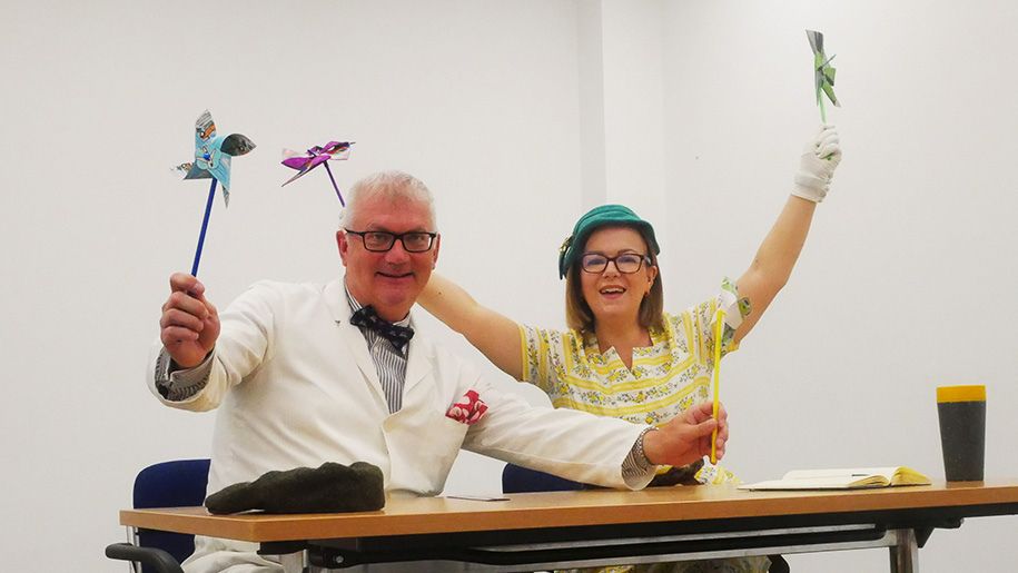 Couple holding colourful fans at British Motor Museum