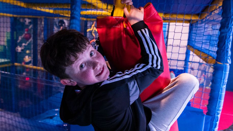Boy swinging from punching bag at Arc Leisure Matlock
