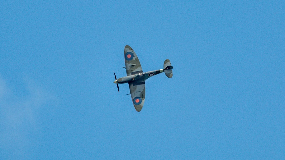 A Spitfire vintage aeroplane against a blue sky.