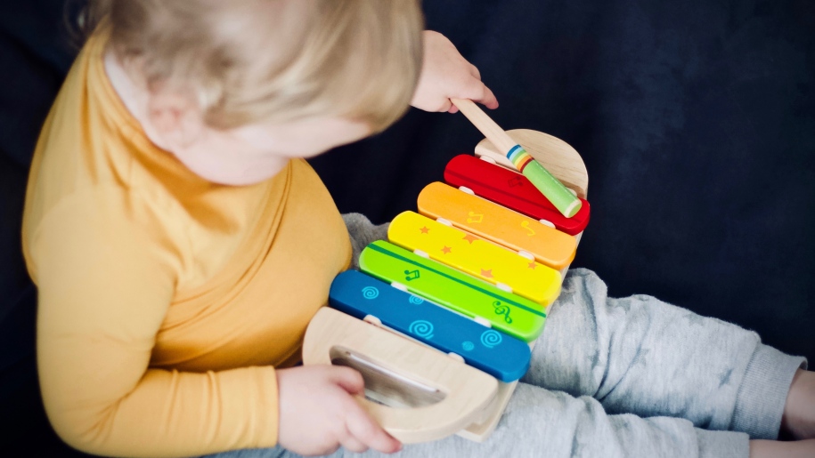 A toddler and wooden xylophone.