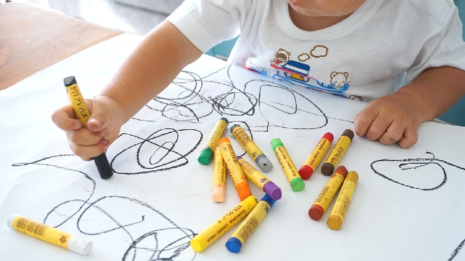 Generic Young child drawing with wax pencils