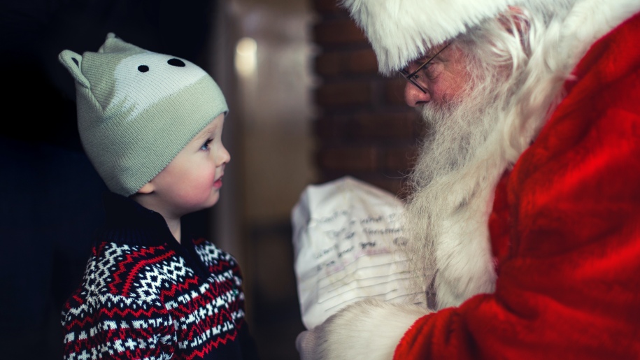 Young child giving Santa his Christmas list.