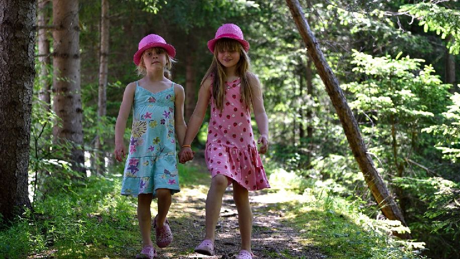 Generic two girls holding hands outdoors in a forest