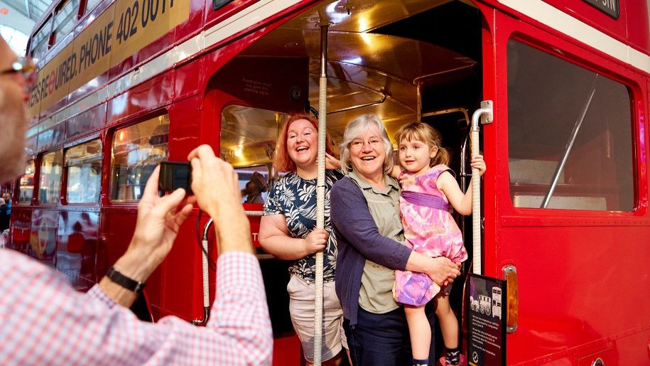Family posing for a photo on a London bus at the London Transport Museum