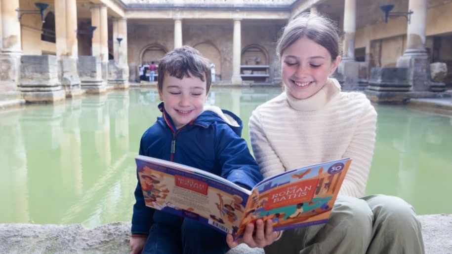 Children reading the Roman Baths activity book at The Roman Baths