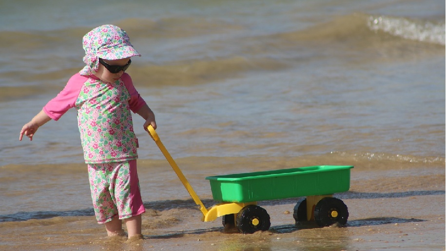 Isle of Wight little girl pulling a cart on the beach