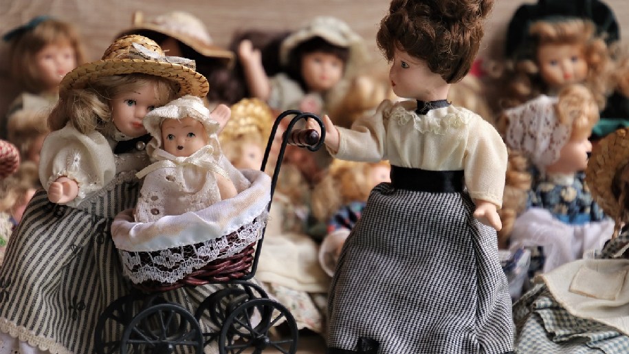 Variety of vintage dolls and one in a pram