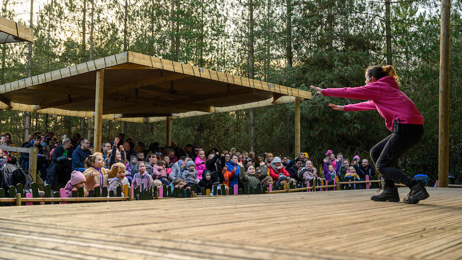Audience watching girl on stage at Bewilderwood Cheshire