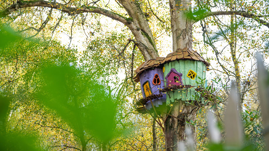 Coulourful mini tree houses in trees at BeWILDerwood Cheshire