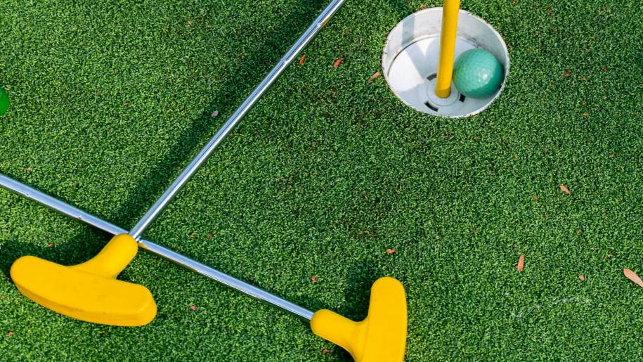Putters and ball on an adventure golf course.