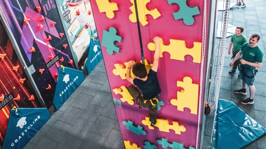 A young climber on a climbing wall at Crazy Climb Swansea.