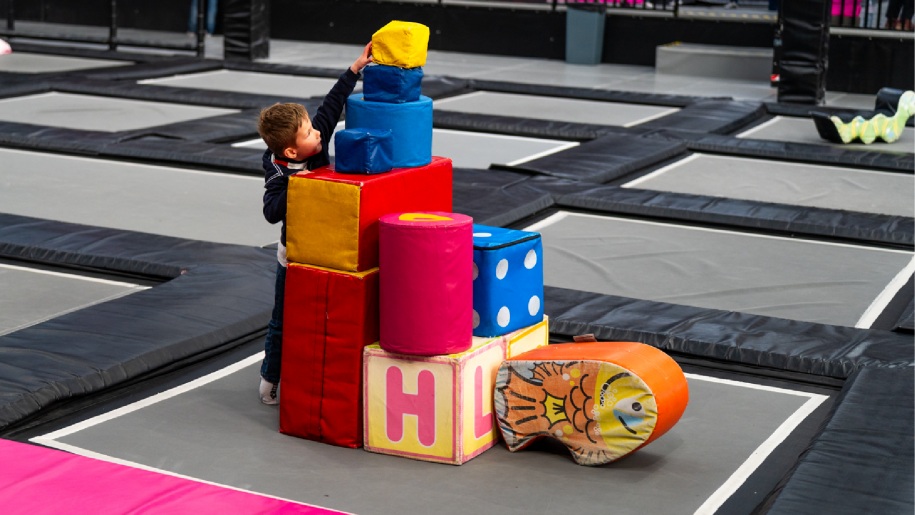 A child playing with soft play bricks on the trampoline court at Freedog Bristol.
