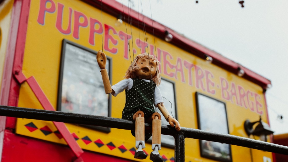 A marionette sitting on the rail around the Puppet Theatre Barge.