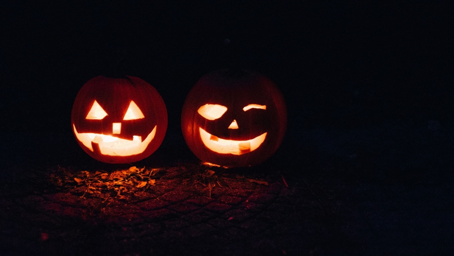 Carved Halloween pumpkins glowing in the dark.