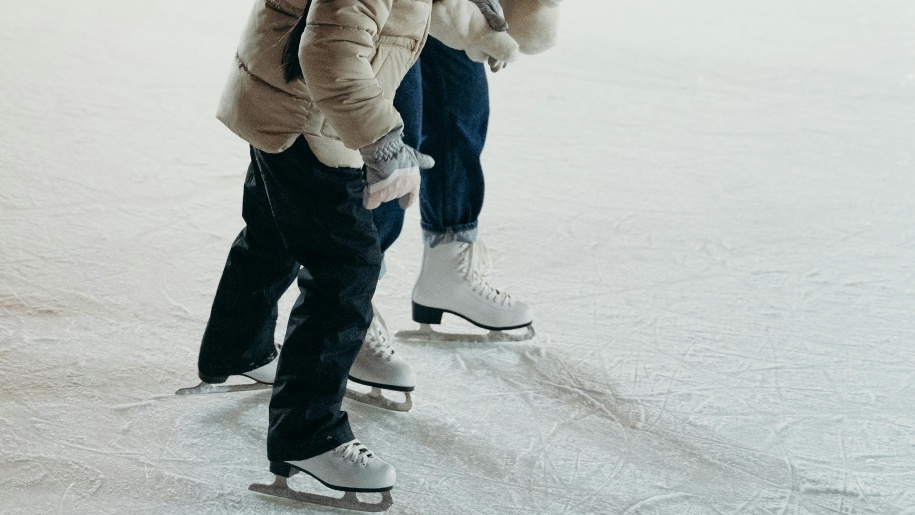 Adult and child ice skating.