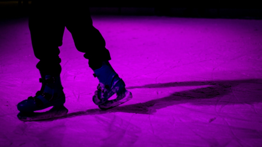 A skater on an illuminated ice rink,