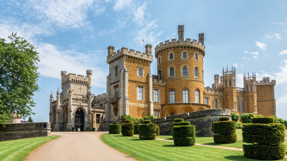 Towers of Belvoir Castle with topiary and lawns in the foreground.