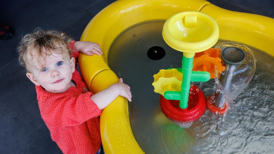 A toddler looking at a colourful interactive display at Techniquest Cardiff.