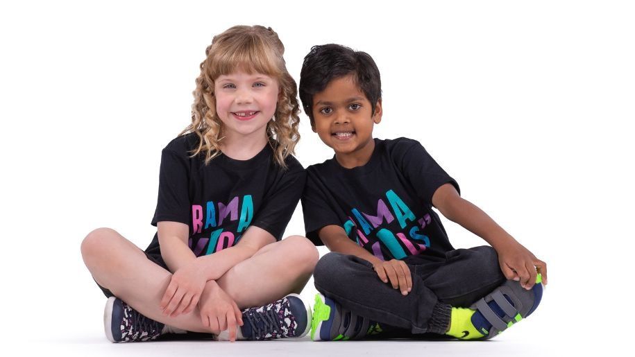 two children sat on the floor smiling