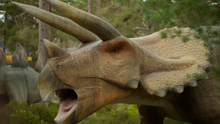 Huge model dinosaur in trees.