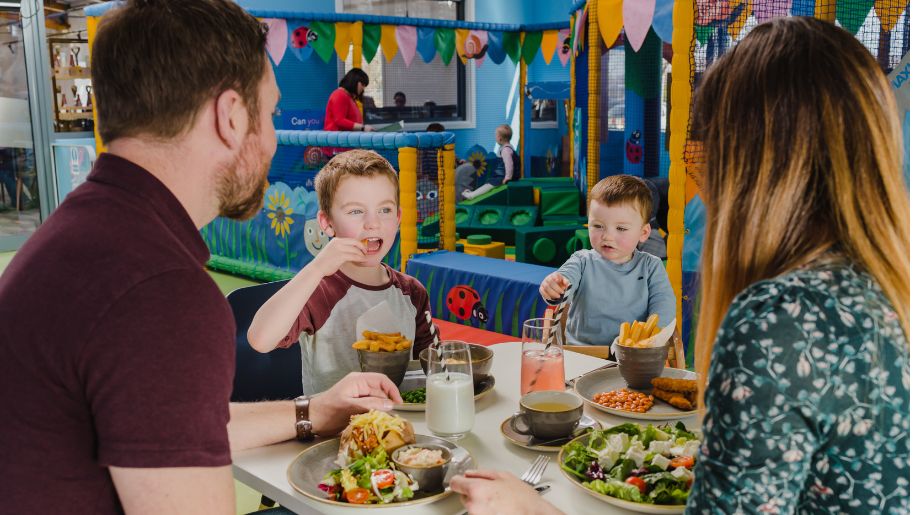 kids eating in a soft play with family