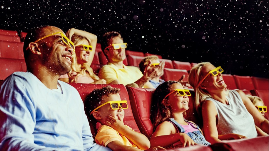 Families wearing special glasses in a 4D cinema.