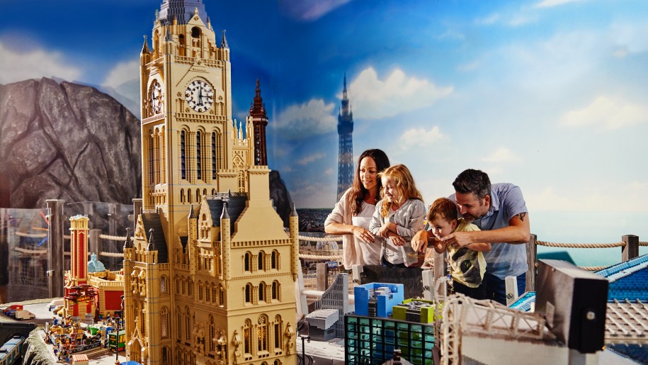 A family looking at buildings made from LEGO bricks.