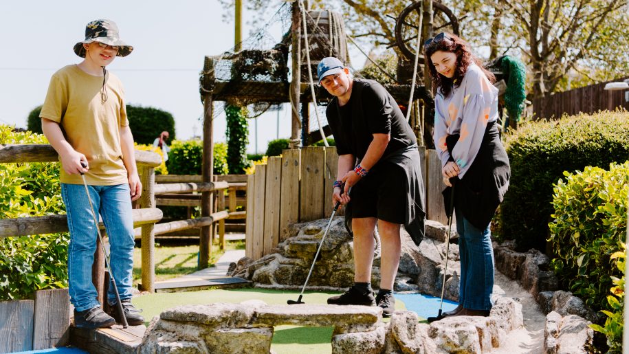Family playing mini golf.
