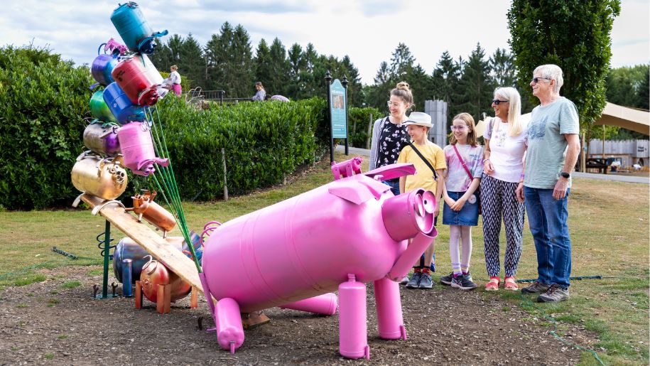 family looking at pig sculpture