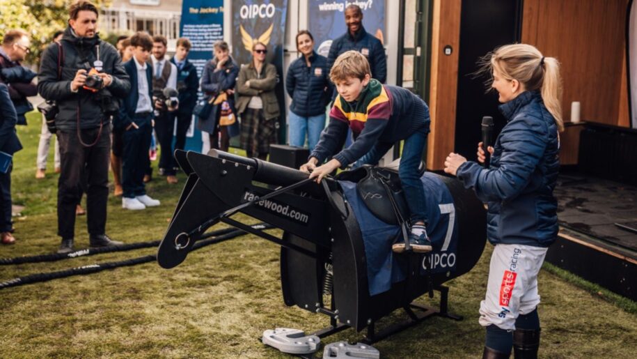 boy rides pretend horse with crowd around