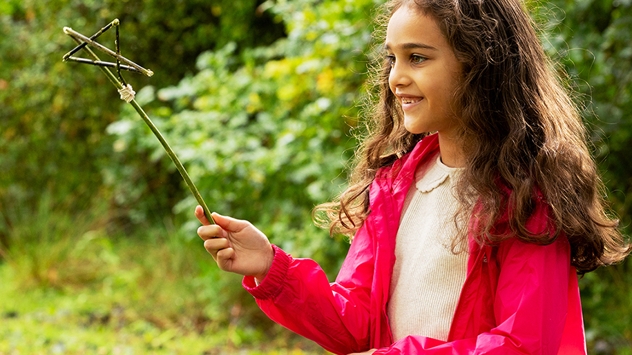 Girl Wand in garden in red coat
