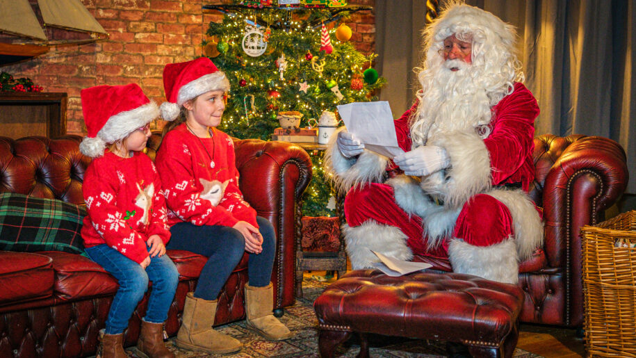 father christmas with two children in santa hats