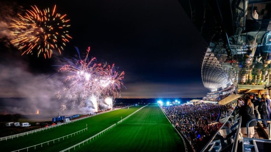 fireworks over the a racecourse with a grand stadium on the right