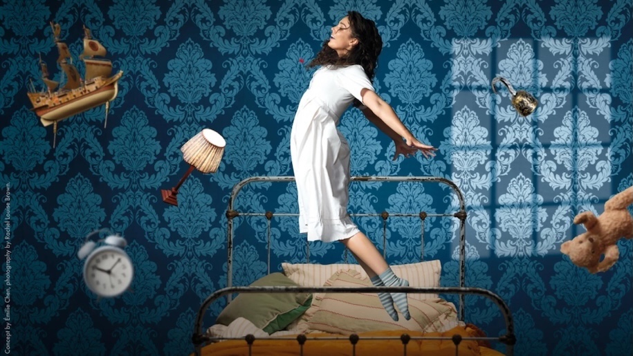 girl in white nightie floats above bed