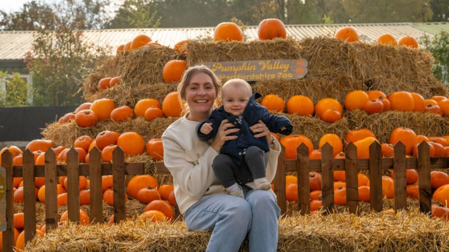mum and baby pose by pumpkins