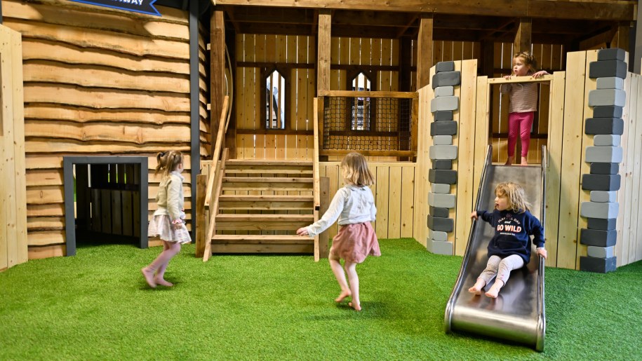 Four girls playing in an indoor adventure playground.