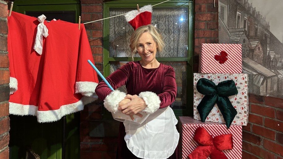 Mrs Claus baking in her kitchen with presents nearby.