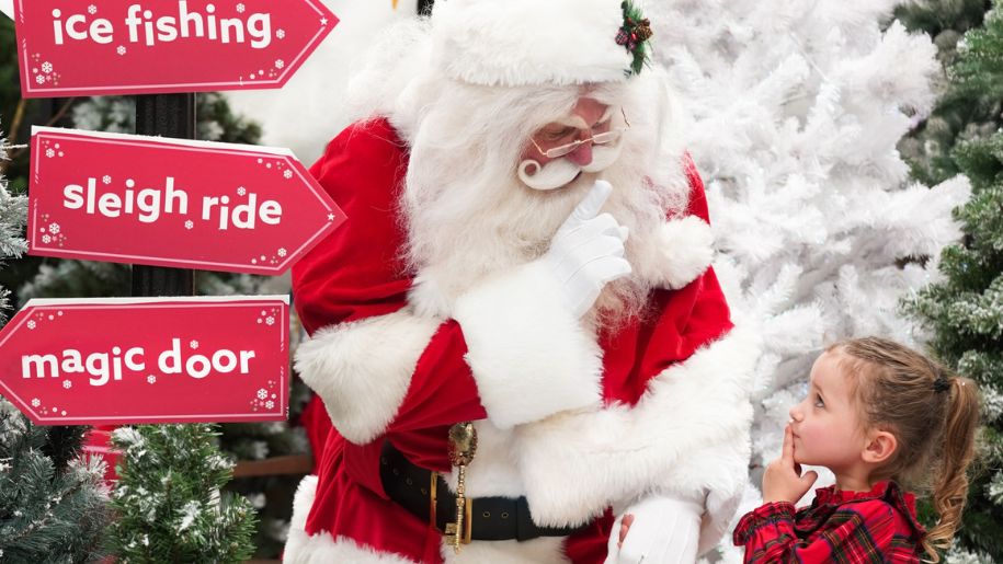 father christmas and little girl with sign for events