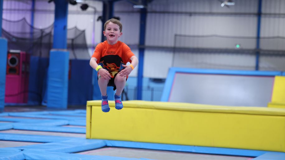 boy in red tshirt jumps on a trampoline