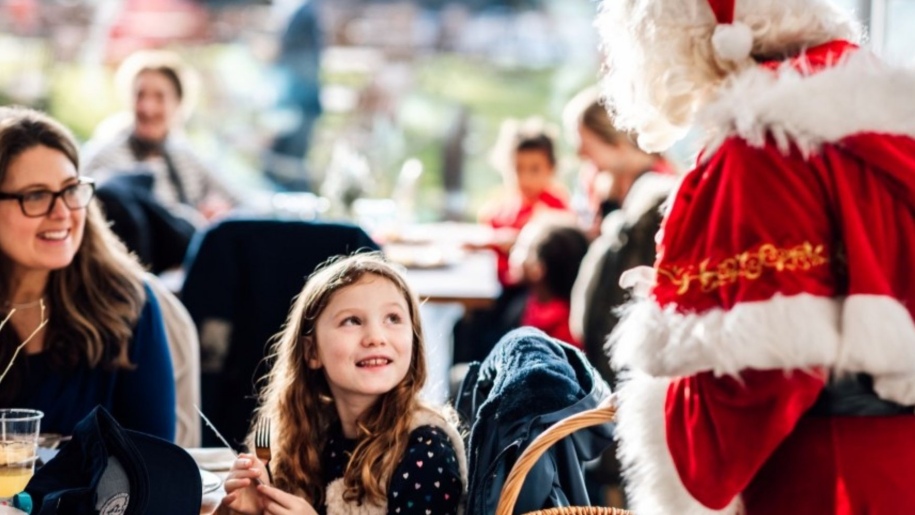 Father Christmas talking to a girl and her mother at Ascot.