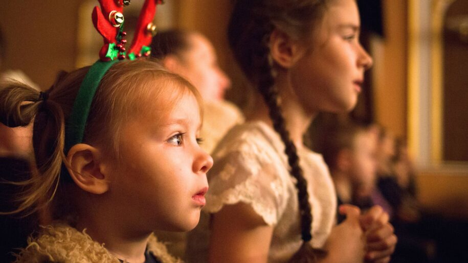 little girl watching show with antlers on